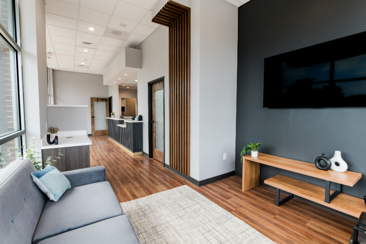 Waiting area with seating, TV, and large windows